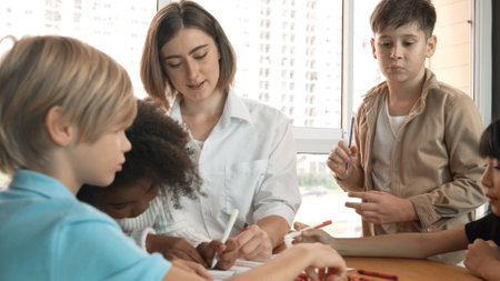 Professional caucasian teacher telling story to diverse student while sitting at table with storybook and colored book. Smart learner listening story while colored picture from instructor. Erudition.の写真素材