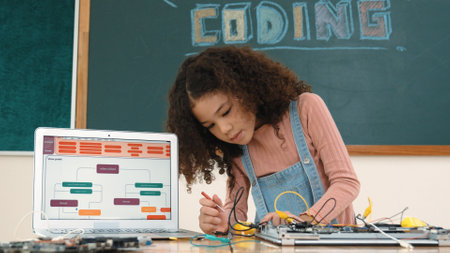 Smart girl inspect and fixing machine by using wire and connect system on table with laptop screen display engineering prompt or program while standing in front of blackboard . Pedagogy.の写真素材