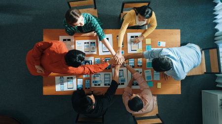 Top view of developer and designer shake hand together at meeting. Software developer handshake and working together with programmer to develop Ux Ui desifn for mobile phone interface. Convocation.の写真素材