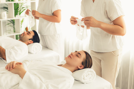Serene modern daylight ambiance of spa salon, couple customer indulges in rejuvenating with facial skincare mask. Facial skin treatment and beauty cosmetology procedure for face. Quiescentの写真素材
