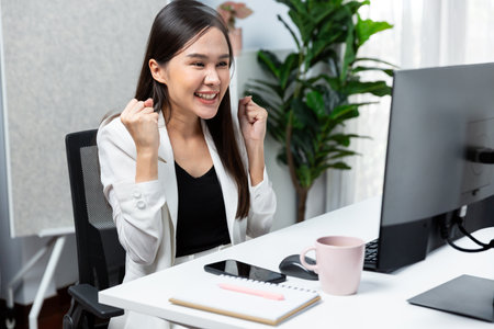Successful in working young Asian businesswoman getting marketing online analysis service project with raising fist up, analyzing on social media website for planning channel sales target. Stratagem.の写真素材