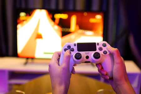 Close up one hands woman player of video game on TV using joystick control with blurry car racing...