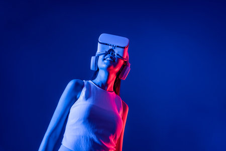 Smart female stand with surrounded by cyberpunk neon light wear VR headset connecting metaverse, futuristic cyberspace community technology. Elegant woman look generated virtual area. Hallucination.の写真素材