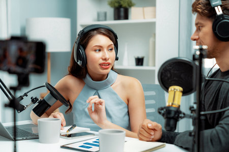 Focus on host channel broadcaster making advice problem in live streaming with listeners surrounded sets of live streaming on talking show radio recorded blurry smartphone at modern studio. Postulate.の写真素材