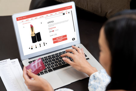 Young woman using laptop with credit card for internet banking, online shopping E commerce by online payment gateway at home. Modern and convenience online shopping with debit card. Blitheの写真素材
