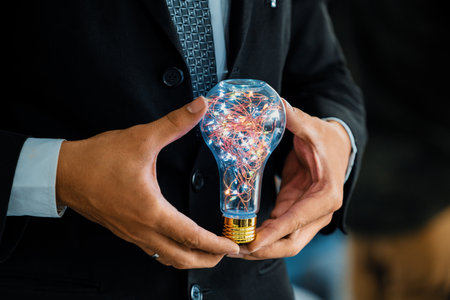 Businessman holding glowing light bulb in hands. Concept of business creativity and ideas. udsの写真素材