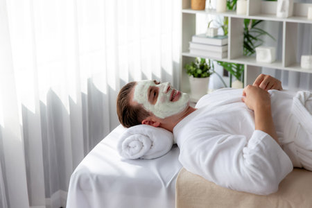 Serene ambiance of spa salon, man customer indulges in rejuvenating with luxurious face cream massage with modern daylight. Facial skin treatment and beauty care concept. Quiescentの写真素材