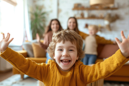 A cheerful young boy with curly hair presents a bright smile in the foreground, with his family relaxing on the couch behind him in a warm living room. AIG41の素材