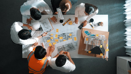 Top down view of skilled engineer team talking while looking at project plan. Aerial view of group of smart interior designer working together and planning for engineering construction. Alimentation.の写真素材