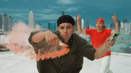 Group of multicultural hipster playing color flare at rooftop. Attractive street dancer holding colored smoke and perform break dance move to hip-hop music. Outdoor sport 2024. Endeavor.の写真素材