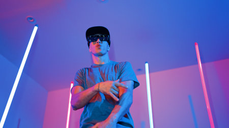 Low angle camera of caucasian dancer wearing fancy glasses and performing break dancing. Attractive man shown energetic performance and movement while looking at camera with confident. Regalement.の写真素材