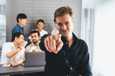 Confidence and happy smiling businessman portrait with background of his colleague and business team working in office. Office worker teamwork and positive workplace concept. Prudentの写真素材