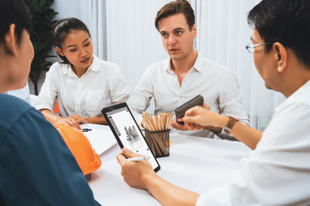 Diverse group of civil engineer and client working together on architectural project, reviewing...