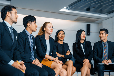 Young Asian and Caucasian audience sitting and listen to speaker in group meeting presentation at office. Businessmen and businesswomen in training workshop. International multicultural business. udsの写真素材