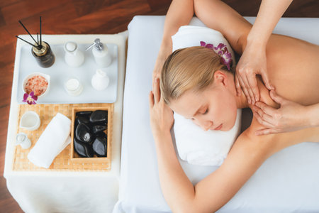 Caucasian woman customer enjoying relaxing anti-stress spa massage and pampering with beauty skin recreation leisure in day light ambient salon spa at luxury resort or hotel. Quiescentの写真素材