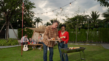 Family all together camp in garden, Old couple grill food for family member. Outdoor camping...
