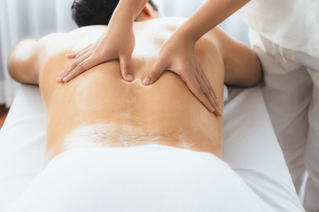 Caucasian man customer enjoying relaxing anti-stress spa massage and pampering with beauty skin recreation leisure in day light ambient salon spa at luxury resort or hotel. Quiescentの写真素材
