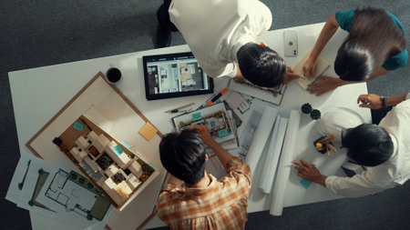 Top down view of smart architect engineer measure blueprint by using architectural equipment while...