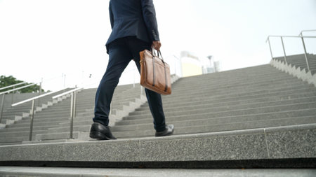 Top view of smart business man walking up stairs with bag in the hand. Professional project manager climb up the stair and going to workplace. Increasing skill, getting promotion, traveling. Exultant.の写真素材