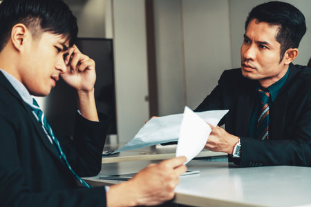 Unhappy business manager and young businessman partner in meeting room at the office. They are under stress because of bad financial document report. Company crisis concept. udsの写真素材