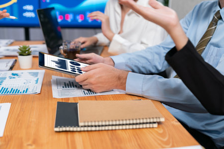Diverse group of business analyst team analyzing financial data report paper on office table. Chart and graph dashboard by business intelligence analysis for strategic marketing planning Habilimentの写真素材