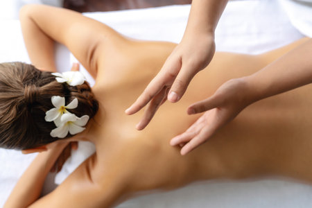 Closeup woman customer enjoying relaxing anti-stress spa massage and pampering with beauty skin recreation leisure in day light ambient salon spa at luxury resort or hotel. Quiescentの写真素材