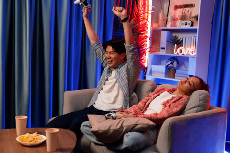 Sitting sofa of happy couple playing video game with joysticks, smiling man playing challenge,...