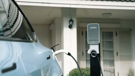 Electric vehicle technology utilized to residential area or home charging station for EV car battery recharge. Eco-friendly transport by clean and sustainable energy for future environment. Synchronosの写真素材