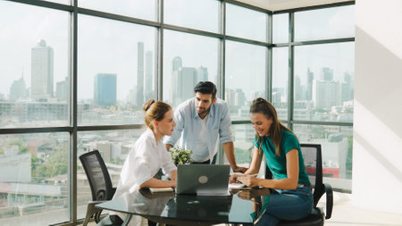 Group of skilled businesspeople sharing idea about marketing plan. Professional business team working together, discussing, talking at meeting table with laptop, document with cityscape. Traceryの写真素材