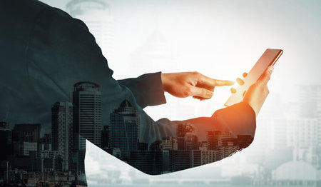 Double Exposure Image of Business Communication Network Technology Concept - Business people using smartphone or mobile phone device on modern cityscape background. udsの写真素材