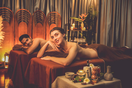 Couple customer having exfoliation treatment in luxury spa salon with warmth candle light ambient. Salt scrub beauty treatment in Health spa body scrub. Quiescentの写真素材