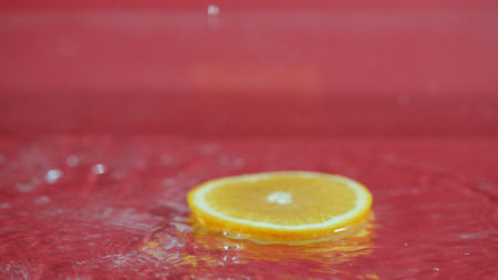 Close up of fresh orange slices water splashing on separated background. Macrography of sliced orange falling and dropping with splashing and spilling water. Freshness and hydration concept. Pabulum.の写真素材