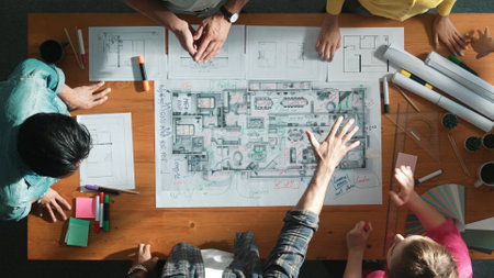 Top view of civil engineer team holding blueprint and standing at table with laptop, project plan...