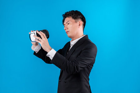 Asian businessman in serious face checking through VR connecting to financial report in futuristic...