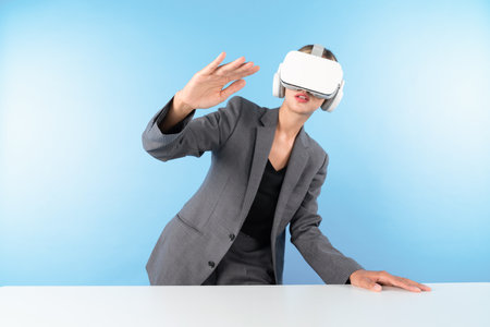 Project manager wearing VR headset and standing while holding innovation technology hologram. Skilled businesswoman connect with visual reality world while looking at data for investment. Contraption.の写真素材