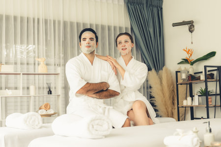 Serene modern daylight ambiance of spa salon, couple customer indulges in rejuvenating with facial skincare mask. Facial skin treatment and beauty cosmetology procedure for face. Quiescentの写真素材