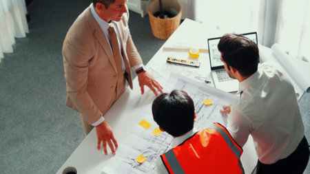 Top view of professional architect engineer team inspect house model while manager holding blueprint...