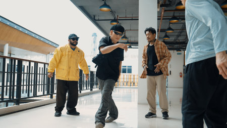 Hipster perform break dancing while partner dancing together at corridor, modern mall. Hip-hop music dancer practice footstep and move to music. Outdoor sport 2024. Active, energetic dance. Hiphop.の写真素材