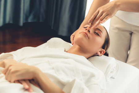 Caucasian woman enjoying relaxing anti-stress head massage and pampering facial beauty skin recreation leisure in dayspa modern light ambient at luxury resort or hotel spa salon. Quiescentの写真素材