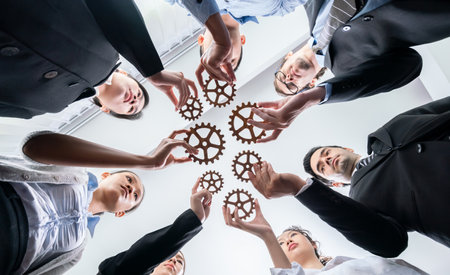 Below view group of multiracial business people joining gear wheels together as effective unity and productive teamwork concept. Efficient system business team process for solution solving. Habilimentの写真素材