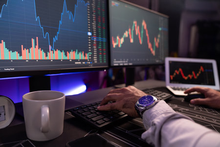 Cropped hands in smart trader businessman concentrating on dynamic stock exchange investment on pc...