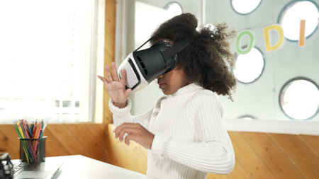 Creative girl wearing VR headset to learning in metaverse. Funny kid enjoy to wearing AI headset and...