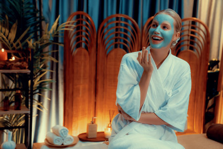 Serene ambiance of spa salon, woman customer indulges in rejuvenating with luxurious face cream massage with warm lighting candle. Facial skin treatment and beauty care concept. Quiescentの写真素材