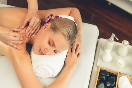 Caucasian woman customer enjoying relaxing anti-stress spa massage and pampering with beauty skin recreation leisure in day light ambient salon spa at luxury resort or hotel. Quiescentの写真素材