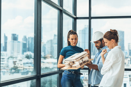 Smart engineer holds house model and explain about house construction to skilled manager. Group of interior designer inspect architectural model. Working together, Civil engineering. Tracery.の写真素材