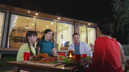Family gather celebrate holiday. Parents, grandparents and girl together to relax and have dinner party food. Outdoor activity for spending time with multigeneration cross generation gap. Divergence.の写真素材