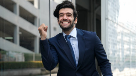 Skilled smart business man dancing with joyful while walking in glass wall. Project manger receive a good news, getting promotion, getting a successful job while express feeling of overjoy. Exultant.の写真素材