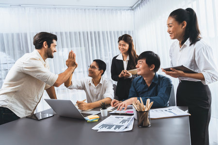 Diverse group of office employee worker high five after making agreement on strategic business marketing planning. Teamwork and positive attitude create productive and supportive workplace. Prudentの写真素材