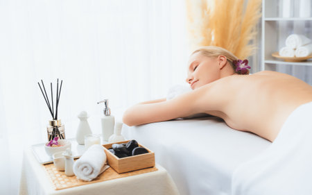 Caucasian woman customer enjoying relaxing anti-stress spa massage and pampering with beauty skin recreation leisure in day light ambient salon spa at luxury resort or hotel. Quiescentの写真素材