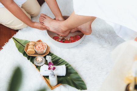 Man indulges in blissful foot massage at luxurious spa salon while masseur give reflexology therapy in gentle day light ambiance resort or hotel foot spa. Quiescentの写真素材